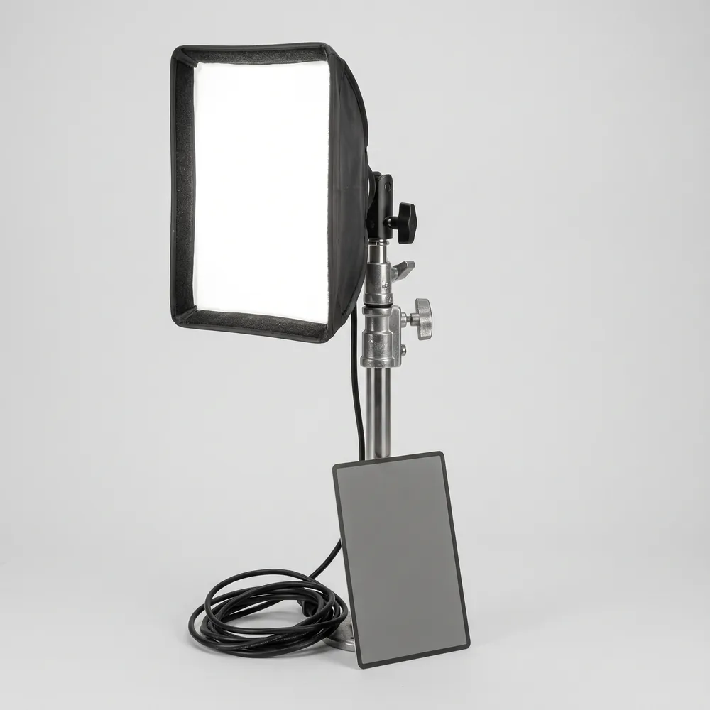 Kleine softbox op een statief met een grijskaart ernaast