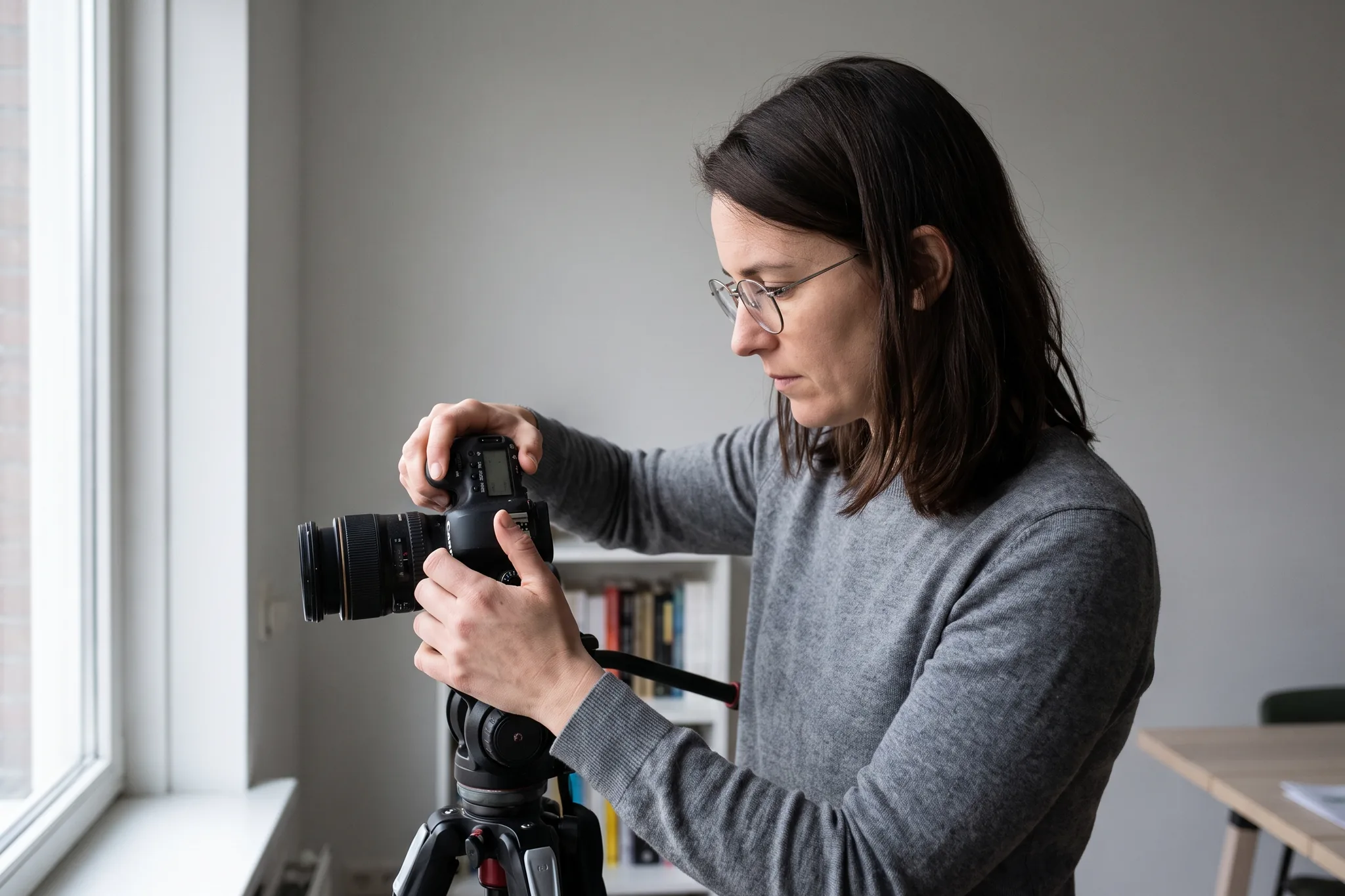Roos stelt een camera in op een statief bij daglicht